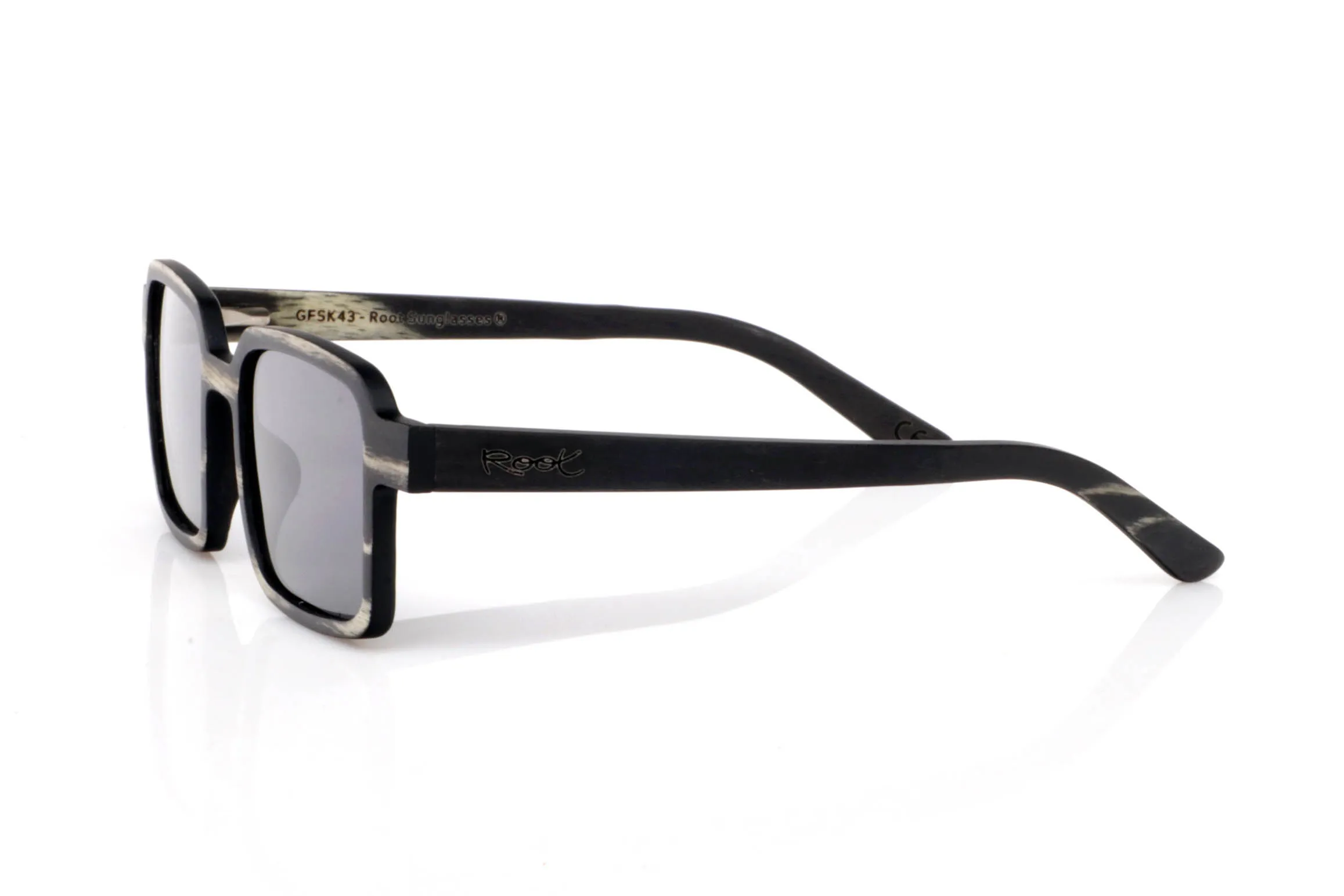 Gafas de Madera Natural de mpingo MANU. Las gafas de madera MANU destacan por su frontal rectangular de líneas marcadas y proporciones compactas, con un aire sólido y muy actual. El acabado en madera mpingo aporta un contraste único entre tonos oscuros y vetas claras que recorren la montura de forma orgánica.

El diseño transmite carácter sin necesidad de excesos. Es una gafa directa, equilibrada y muy cómoda, pensada para quienes buscan algo diferente pero fácil de llevar en el día a día.

Las varillas mantienen la continuidad del tono oscuro, reforzando esa sensación de pieza compacta y bien definida, donde cada detalle suma.

Protección completa frente a los rayos UV.

Medidas: 135x45
Calibre: 45 Venta al Por Mayor y Detalle | Root Sunglasses® 