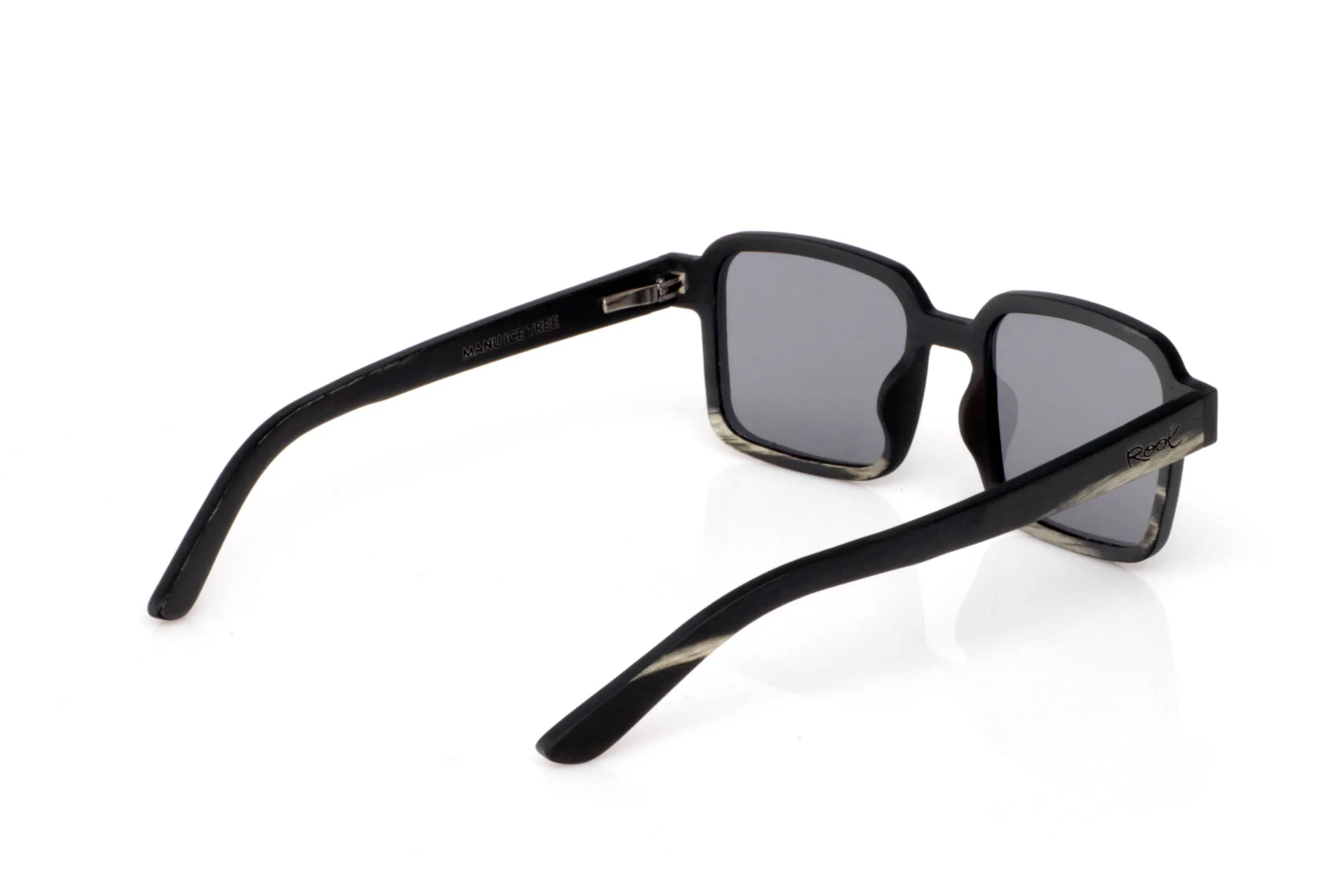 Gafas de Madera Natural de mpingo MANU. Las gafas de madera MANU destacan por su frontal rectangular de líneas marcadas y proporciones compactas, con un aire sólido y muy actual. El acabado en madera mpingo aporta un contraste único entre tonos oscuros y vetas claras que recorren la montura de forma orgánica.

El diseño transmite carácter sin necesidad de excesos. Es una gafa directa, equilibrada y muy cómoda, pensada para quienes buscan algo diferente pero fácil de llevar en el día a día.

Las varillas mantienen la continuidad del tono oscuro, reforzando esa sensación de pieza compacta y bien definida, donde cada detalle suma.

Protección completa frente a los rayos UV.

Medidas: 135x45
Calibre: 45 Venta al Por Mayor y Detalle | Root Sunglasses® 