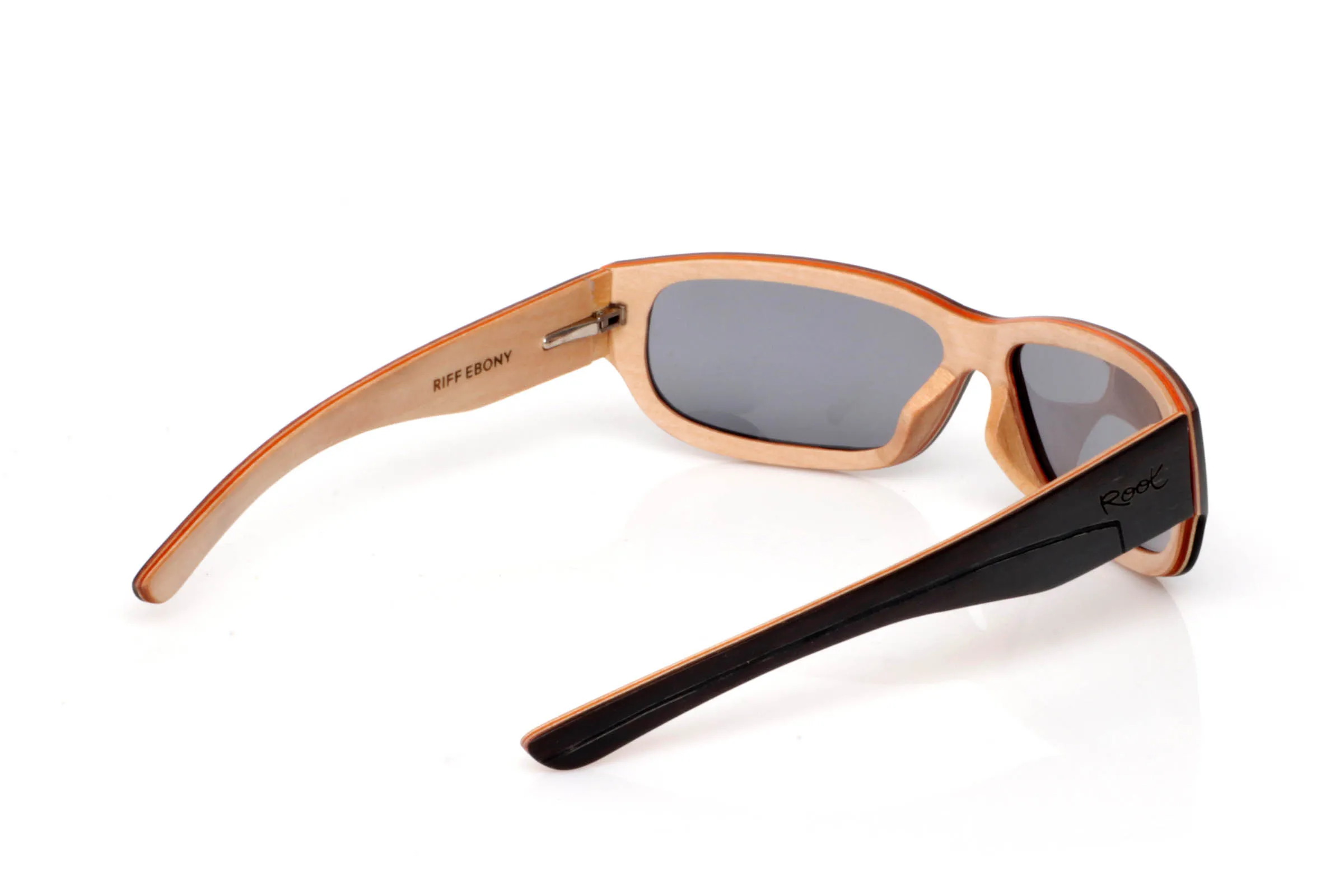 Wood eyewear of Ebony RIFF SK. RIFF wooden sunglasses feature an elongated, wrap-style design with a soft rectangular front that fits naturally to the face, giving them a modern and slightly sporty feel.

The contrast between the dark ebony exterior and the lighter inner wood creates a visually light yet strong piece. A balance between strength and natural aesthetics that defines the frame.

The temples continue this contrast, with an ergonomic shape that ensures comfort and stability for everyday wear.

Full UV protection.

Size: 145x42
Lens width: 62 for Wholesale & Retail | Root Sunglasses® 