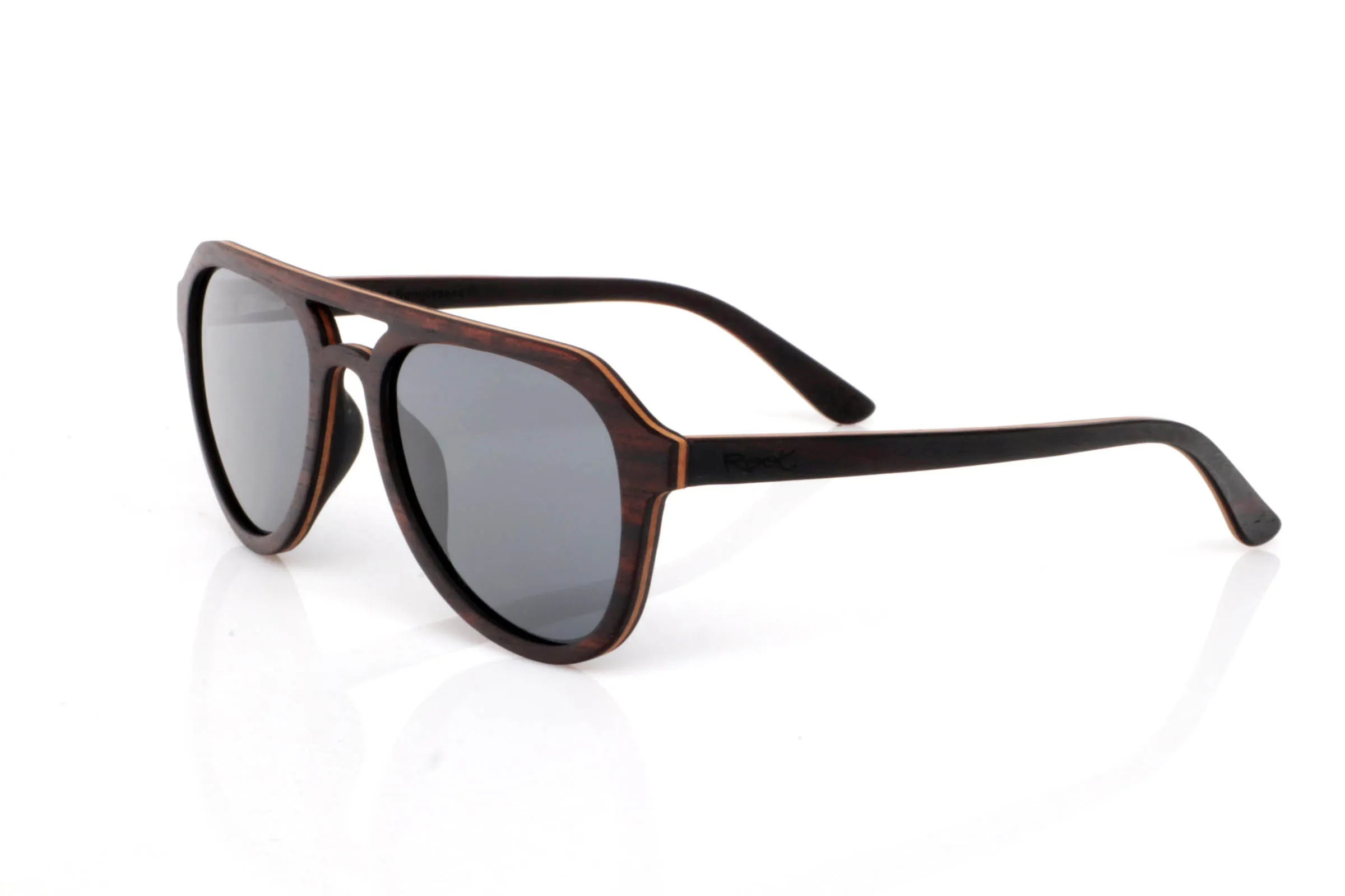 Wood eyewear of ebony modelo TOMMY. TOMMY wooden sunglasses stand out with a deep ebony front, featuring a subtle natural grain that brings elegance without excess. The design includes a defined bridge that adds a slightly retro touch, balanced by soft lines that make them easy to wear.

The contrast between the dark ebony exterior and the lighter inner wood creates a natural detail that feels refined rather than flashy. A frame with presence, yet versatile for everyday use.

The shape, somewhere between rounded and structured, adapts well to different face types, adding personality without being too bold.

Lightweight, comfortable, and with the organic feel of real wood.

Full UV protection.

Size: 142x52
Lens width: 53 | Root Sunglasses® 