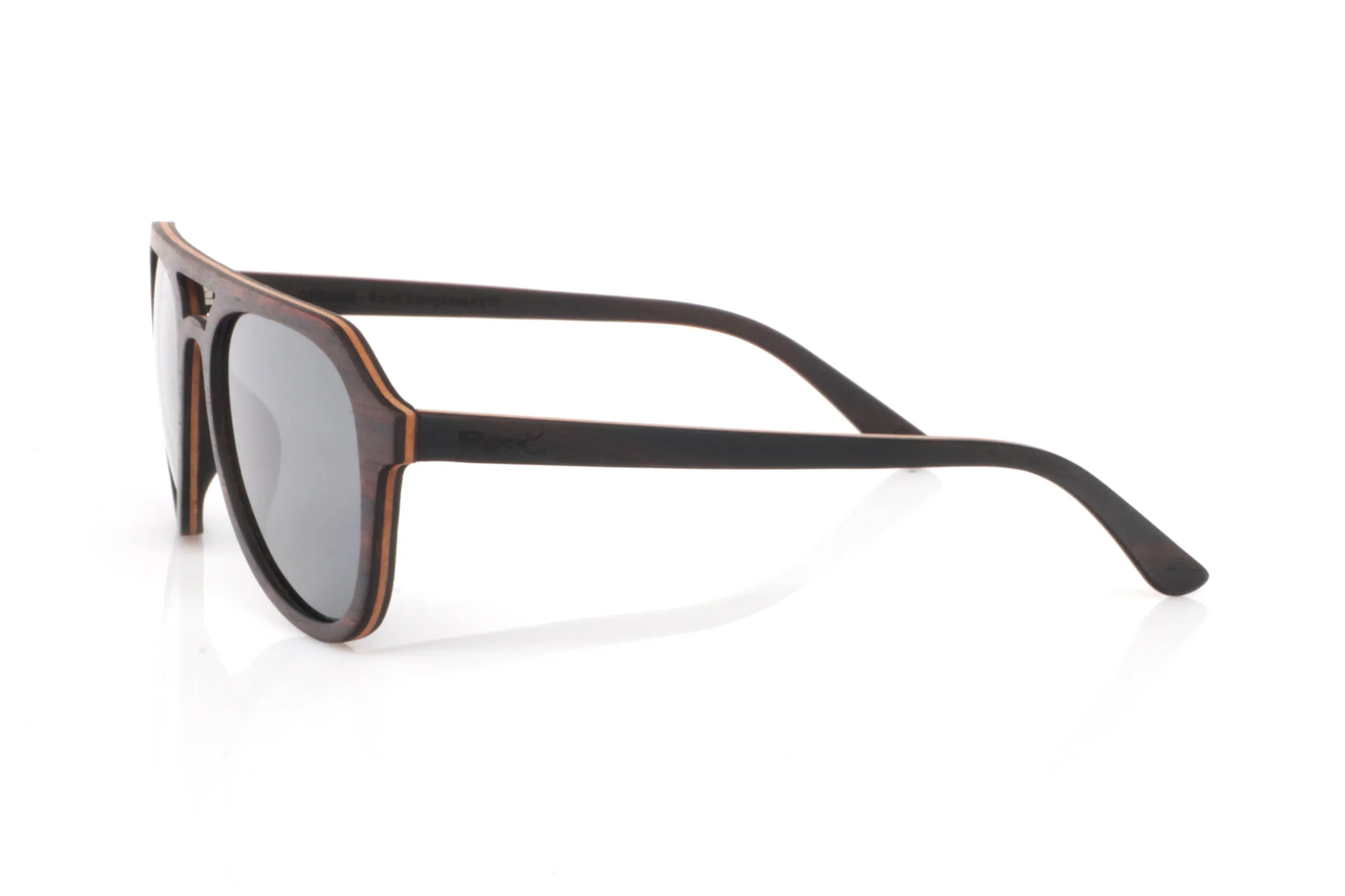 Wood eyewear of ebony TOMMY. TOMMY wooden sunglasses stand out with a deep ebony front, featuring a subtle natural grain that brings elegance without excess. The design includes a defined bridge that adds a slightly retro touch, balanced by soft lines that make them easy to wear.

The contrast between the dark ebony exterior and the lighter inner wood creates a natural detail that feels refined rather than flashy. A frame with presence, yet versatile for everyday use.

The shape, somewhere between rounded and structured, adapts well to different face types, adding personality without being too bold.

Lightweight, comfortable, and with the organic feel of real wood.

Full UV protection.

Size: 142x52
Lens width: 53 for Wholesale & Retail | Root Sunglasses® 