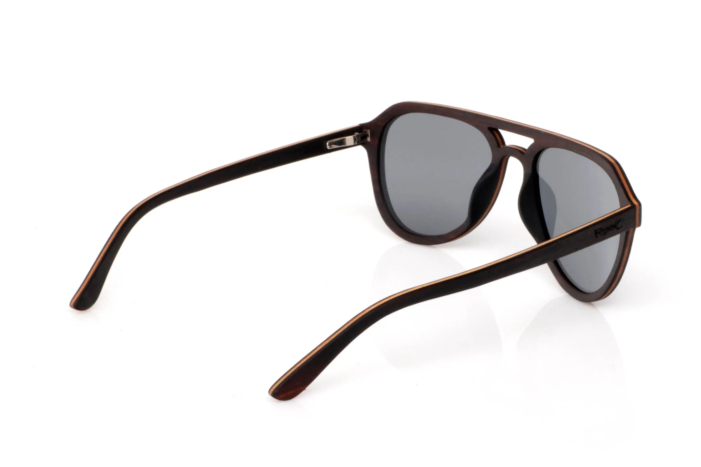 Wood eyewear of ebony TOMMY. TOMMY wooden sunglasses stand out with a deep ebony front, featuring a subtle natural grain that brings elegance without excess. The design includes a defined bridge that adds a slightly retro touch, balanced by soft lines that make them easy to wear.

The contrast between the dark ebony exterior and the lighter inner wood creates a natural detail that feels refined rather than flashy. A frame with presence, yet versatile for everyday use.

The shape, somewhere between rounded and structured, adapts well to different face types, adding personality without being too bold.

Lightweight, comfortable, and with the organic feel of real wood.

Full UV protection.

Size: 142x52
Lens width: 53 for Wholesale & Retail | Root Sunglasses® 