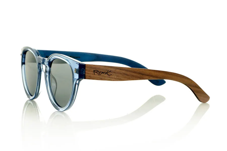 Wood eyewear of Walnut JANE. JANE Sunglasses with walnut wood temples, a translucent blue PC front, and a blue-tinted maple wood interior finish that matches the front. A model that stands out for its lightweight, modern, and balanced design suitable for smaller faces, perfect for those seeking style without sacrificing natural materials. Polarized lenses with UV protection for optimal visual comfort. Measurements: 139 x 50 mm. Caliber 47. for Wholesale & Retail | Root Sunglasses® 