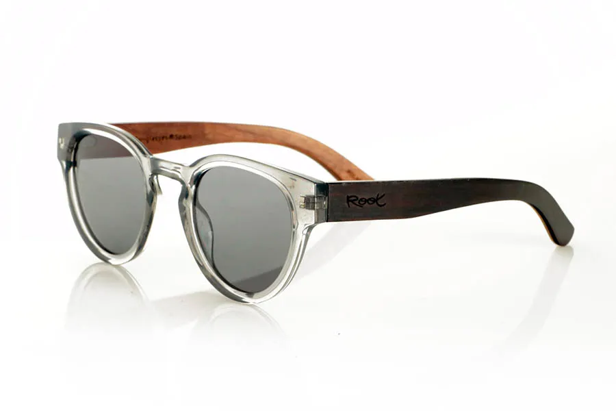 Gafas de Madera Natural de Walnut JOSS. JOSS Gafas de sol con patillas de madera de nogal oscuro en el exterior y acabado interior en nogal claro intercalado con una lámina de arce natural. El frontal en PC gris translúcido aporta un toque actual y versátil a este modelo ligero y bien proporcionado, ideal para rostros más pequeños. Lentes polarizadas con protección UV que garantizan confort visual y protección solar. Medidas: 139x50 mm. Calibre 47. Venta al Por Mayor y Detalle | Root Sunglasses® 