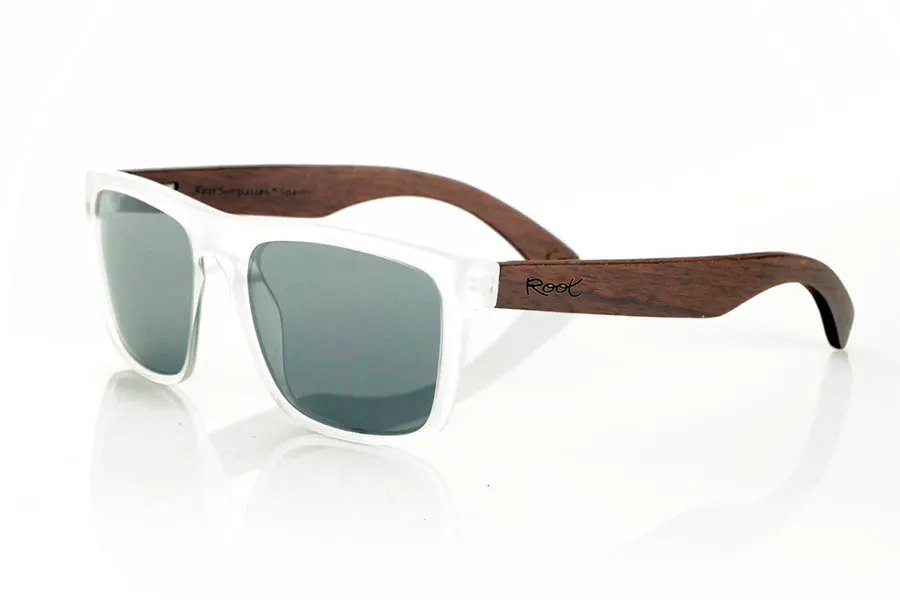Wood eyewear of Walnut ROUSHEN. ROUSHEN sunglasses with solid dark walnut wood temples and a matte transparent front for a fresh, contemporary look. The contrast between the warmth of the wood and the transparency of the front makes them an original and versatile choice for everyday wear. Polarized lenses with UV protection. Measurements: 145 x 49 mm. Caliber 56 for Wholesale & Retail | Root Sunglasses® 