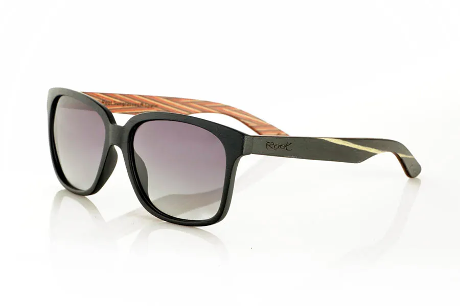 Wood eyewear of Zebrano PABLO. PABLO Sunglasses with laminated black Zebrawood (Black Ice Tree) temples with its characteristic light grain, and a multicolored skateboard-style interior. The matte black front adds a sober touch that contrasts with the vibrant interior, resulting in a modern and original design. Lightweight and comfortable for everyday wear, with polarized lenses and UV protection for greater comfort and visual safety. Measurements: 143 x 50 mm. Caliber 55. for Wholesale & Retail | Root Sunglasses® 