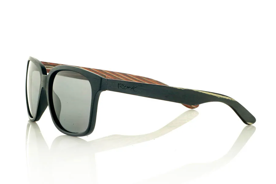 Wood eyewear of Zebrano PABLO. PABLO Sunglasses with laminated black Zebrawood (Black Ice Tree) temples with its characteristic light grain, and a multicolored skateboard-style interior. The matte black front adds a sober touch that contrasts with the vibrant interior, resulting in a modern and original design. Lightweight and comfortable for everyday wear, with polarized lenses and UV protection for greater comfort and visual safety. Measurements: 143 x 50 mm. Caliber 55. for Wholesale & Retail | Root Sunglasses® 