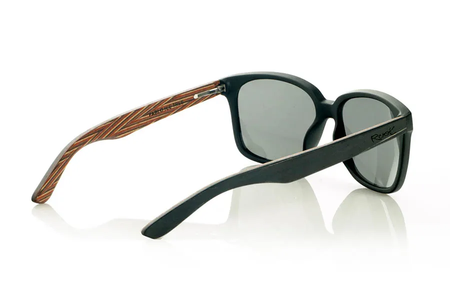 Wood eyewear of Zebrano PABLO. PABLO Sunglasses with laminated black Zebrawood (Black Ice Tree) temples with its characteristic light grain, and a multicolored skateboard-style interior. The matte black front adds a sober touch that contrasts with the vibrant interior, resulting in a modern and original design. Lightweight and comfortable for everyday wear, with polarized lenses and UV protection for greater comfort and visual safety. Measurements: 143 x 50 mm. Caliber 55. for Wholesale & Retail | Root Sunglasses® 