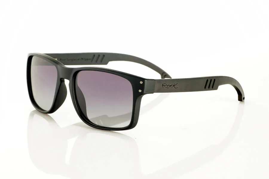 Wood eyewear of Ebony MATT. MATT Sunglasses with solid ebony wood temples and decorative temple. The matte black front features two metal dots on each side, reinforcing its modern and distinctive style. The die-cut temples add a distinctive touch. A robust, comfortable, and stylish model, equipped with blue mirror polarized lenses and UV protection. Measurements: 146 x 48 mm. Lens width: 55 mm. for Wholesale & Retail | Root Sunglasses® 