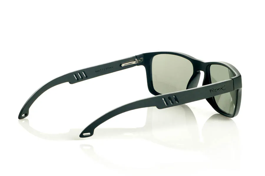Wood eyewear of Ebony MATT. MATT Sunglasses with solid ebony wood temples and decorative temple. The matte black front features two metal dots on each side, reinforcing its modern and distinctive style. The die-cut temples add a distinctive touch. A robust, comfortable, and stylish model, equipped with blue mirror polarized lenses and UV protection. Measurements: 146 x 48 mm. Lens width: 55 mm. for Wholesale & Retail | Root Sunglasses® 