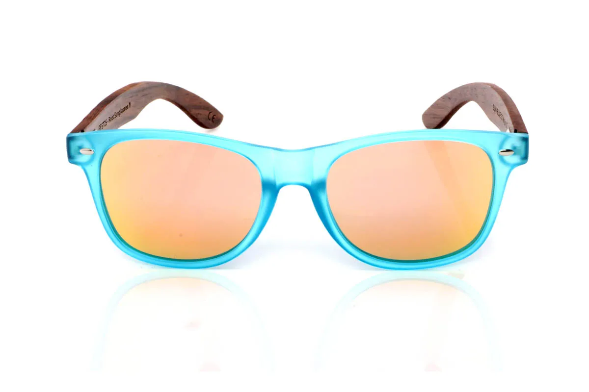 Gafas de Madera Natural de Walnut SUN BLUE ST. Las gafas de madera SUN BLUE ST transmiten frescura desde el primer vistazo. Un frontal limpio y ligero, con montura transparente mate en tono azul que suaviza la luz y aporta un efecto sutil y equilibrado. Una forma pensada para el día a día, fácil de llevar y sin complicaciones.

Las varillas de madera de nogal aportan ese contraste natural que define el modelo, con veta visible y un tacto cálido que conecta con lo auténtico. Son cómodas, ligeras y con una energía suave que acompaña sin imponerse. De esas gafas que encajan contigo sin esfuerzo.

Protección completa frente a los rayos UV.

Medidas: 148x49
Calibre: 54 Venta al Por Mayor y Detalle | Root Sunglasses® 