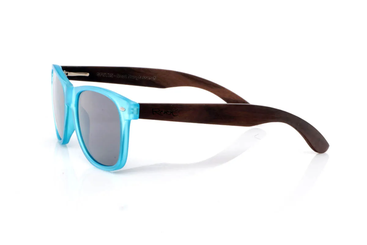 Gafas de Madera Natural de Walnut SUN BLUE ST. Las gafas de madera SUN BLUE ST transmiten frescura desde el primer vistazo. Un frontal limpio y ligero, con montura transparente mate en tono azul que suaviza la luz y aporta un efecto sutil y equilibrado. Una forma pensada para el día a día, fácil de llevar y sin complicaciones.

Las varillas de madera de nogal aportan ese contraste natural que define el modelo, con veta visible y un tacto cálido que conecta con lo auténtico. Son cómodas, ligeras y con una energía suave que acompaña sin imponerse. De esas gafas que encajan contigo sin esfuerzo.

Protección completa frente a los rayos UV.

Medidas: 148x49
Calibre: 54 Venta al Por Mayor y Detalle | Root Sunglasses® 
