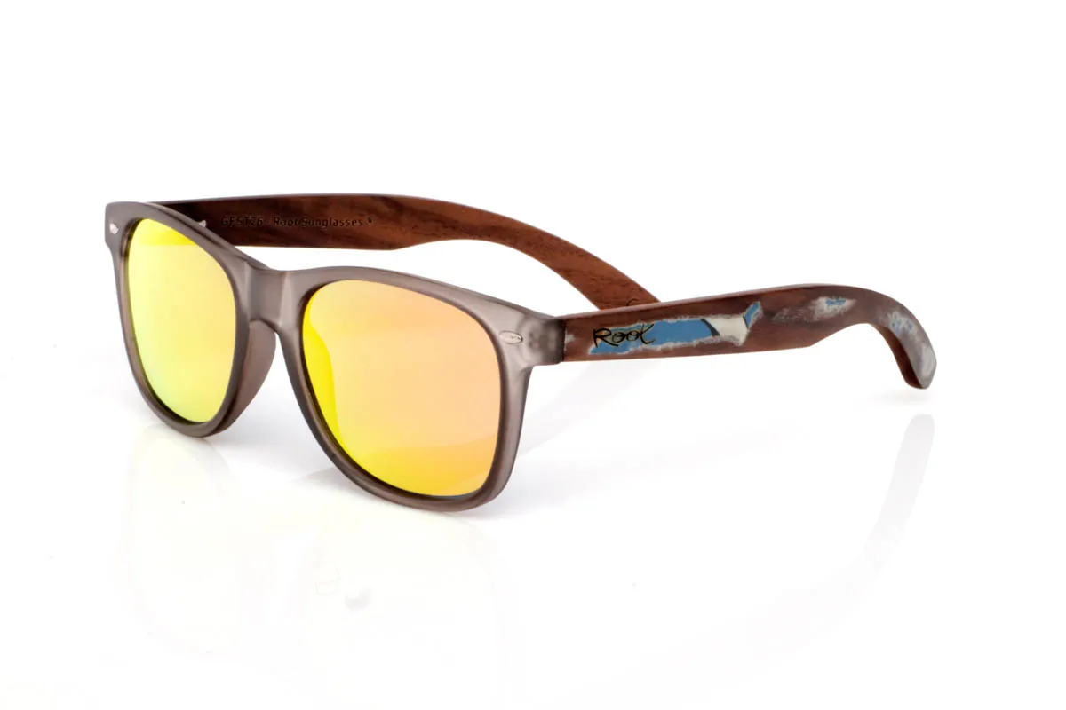 Gafas de Madera Natural de Walnut SKA GREY ST. Las gafas de madera SKA GREY ST tienen ese equilibrio que funciona sin esfuerzo. Un frontal limpio y ligero, con montura transparente mate en tono gris que suaviza la luz y aporta un efecto sobrio y actual. Una forma pensada para el día a día, fácil de llevar y sin complicaciones.

Las varillas de madera con decoración vintage aportan el contraste natural, con veta visible y un acabado que transmite autenticidad. Son cómodas, ligeras y con personalidad tranquila. De esas gafas que no necesitan destacar para encajar.

Protección completa frente a los rayos UV.

Medidas: 148x49
Calibre: 54 Venta al Por Mayor y Detalle | Root Sunglasses® 