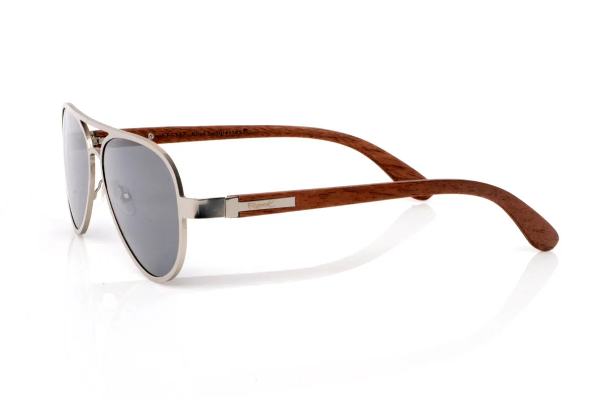 Gafas de Madera Natural de Walnut ESSEN ST. Las gafas de madera ESSEN ST destacan por su diseño limpio de inspiración aviador en metal silver mate, ligero, equilibrado y fácil de llevar en el día a día.

Las varillas de madera de nogal aportan calidez y contraste, con veta visible y una textura natural que conecta con la esencia del material. La combinación de metal y madera crea un equilibrio armonioso entre precisión y autenticidad. Son ligeras, cómodas y con una personalidad sutil pero definida.

Protección completa frente a los rayos UV.

Medidas: 147x50
Calibre: 57
 Venta al Por Mayor y Detalle | Root Sunglasses® 