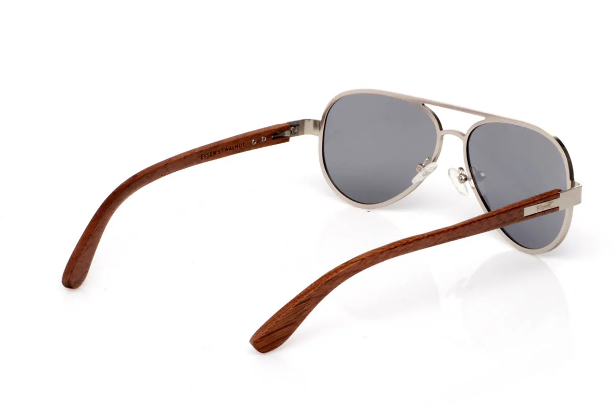 Gafas de Madera Natural de Walnut ESSEN ST. Las gafas de madera ESSEN ST destacan por su diseño limpio de inspiración aviador en metal silver mate, ligero, equilibrado y fácil de llevar en el día a día.

Las varillas de madera de nogal aportan calidez y contraste, con veta visible y una textura natural que conecta con la esencia del material. La combinación de metal y madera crea un equilibrio armonioso entre precisión y autenticidad. Son ligeras, cómodas y con una personalidad sutil pero definida.

Protección completa frente a los rayos UV.

Medidas: 147x50
Calibre: 57
 Venta al Por Mayor y Detalle | Root Sunglasses® 