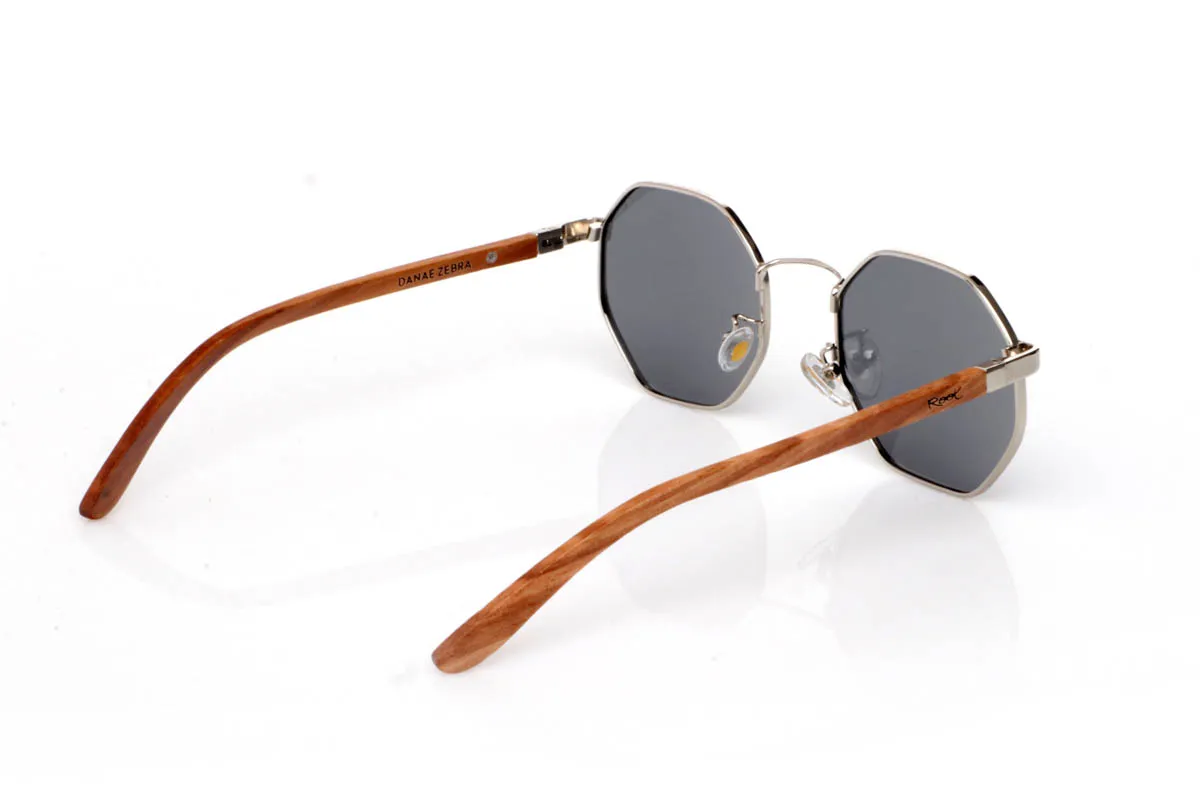 Wood eyewear of Zebrano DANAE. The DANAE ZEBRANO wooden sunglasses stand out for their balanced geometric shape, with a lightweight metal front that brings visual clarity and a contemporary feel. A design that sits between organic and structured, enhancing the face without feeling excessive, making them easy to wear every day.

The zebrano wood temples add character and texture, with a distinctive grain that creates a unique and natural visual effect. The contrast between metal and wood reinforces their personality while keeping them lightweight and comfortable. The kind of sunglasses that add style without trying too hard.

Full UV protection.

Size: 140x50
Lens width: 53 for Wholesale & Retail | Root Sunglasses® 