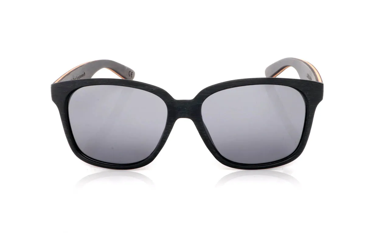 Gafas de Madera Natural de Ébano LISBOA. Las gafas de madera LISBOA destacan por su diseño limpio y atemporal, con un frontal en tono negro profundo que aporta carácter sin excesos. Su forma suave y equilibrada las hace muy fáciles de llevar en el día a día, con una presencia discreta pero firme.

Las varillas combinan maderas de ébano,nogal y zebrano, creando un contraste natural único con vetas visibles y un juego de tonos cálidos que aportan riqueza al conjunto. El resultado es una gafa cómoda, ligera y con personalidad serena. De esas que encajan contigo sin esfuerzo.

Protección completa frente a los rayos UV.

Medidas: 143x51
Calibre: 54 Venta al Por Mayor y Detalle | Root Sunglasses® 
