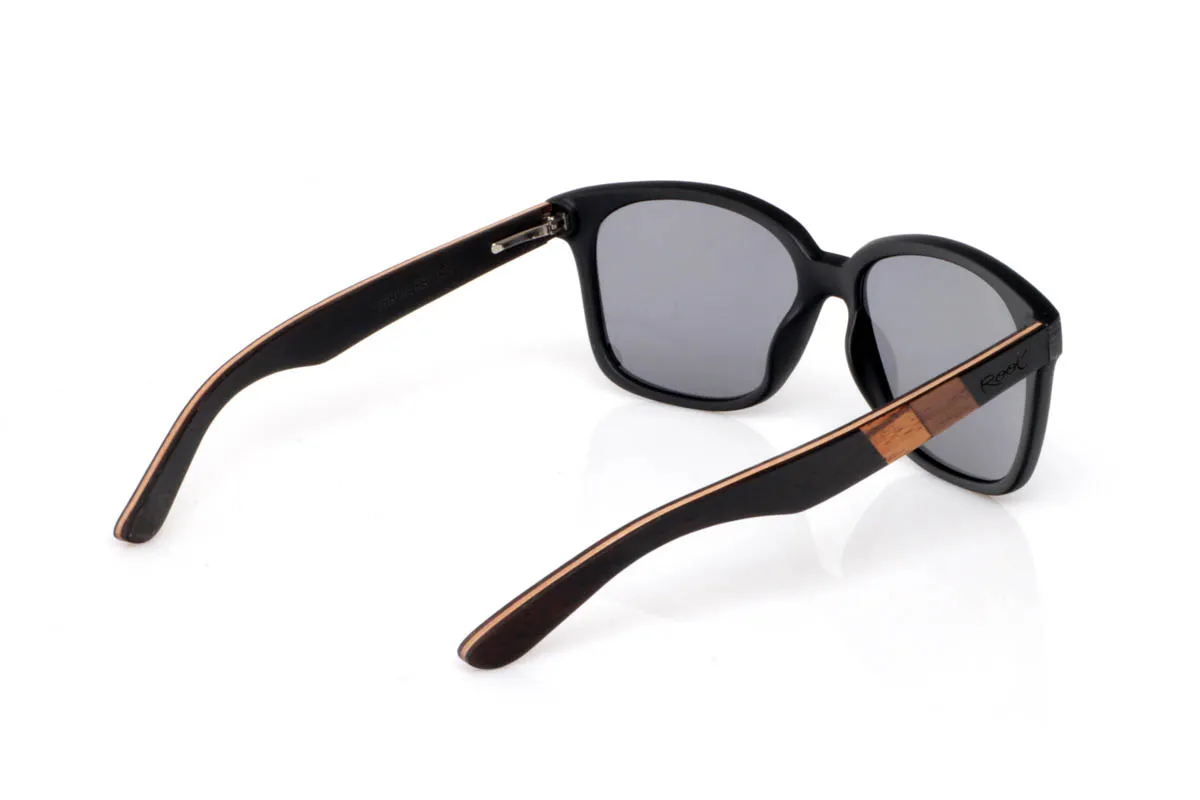 Gafas de Madera Natural de Ébano LISBOA. Las gafas de madera LISBOA destacan por su diseño limpio y atemporal, con un frontal en tono negro profundo que aporta carácter sin excesos. Su forma suave y equilibrada las hace muy fáciles de llevar en el día a día, con una presencia discreta pero firme.

Las varillas combinan maderas de ébano,nogal y zebrano, creando un contraste natural único con vetas visibles y un juego de tonos cálidos que aportan riqueza al conjunto. El resultado es una gafa cómoda, ligera y con personalidad serena. De esas que encajan contigo sin esfuerzo.

Protección completa frente a los rayos UV.

Medidas: 143x51
Calibre: 54 Venta al Por Mayor y Detalle | Root Sunglasses® 