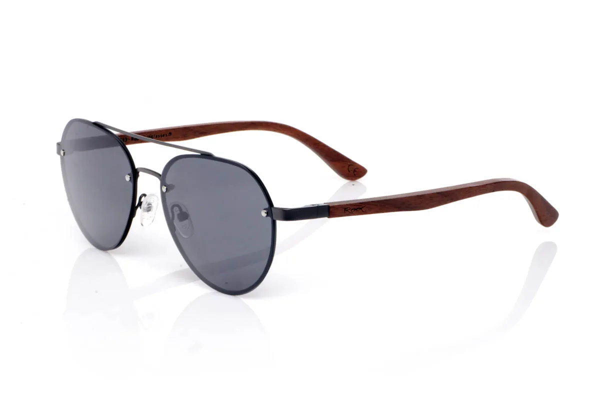 Gafas de Madera Natural de Walnut MISURI ST. Las gafas de madera MISURI ST apuestan por un diseño de inspiración aviador con líneas limpias y estructura metálica fina en tono oscuro, que aporta un aire atemporal y fácil de llevar. Su forma equilibrada estiliza sin exagerar, encajando de forma natural en el día a día.

Las varillas de madera de nogal aportan calidez y contraste, con veta visible y un tacto natural que refuerza la esencia del material. La combinación de metal y madera crea un conjunto ligero, cómodo y con carácter sutil. De esas gafas que acompañan sin imponerse.

Protección completa frente a los rayos UV.

Medidas: 144x51
Calibre: 54 Venta al Por Mayor y Detalle | Root Sunglasses® 