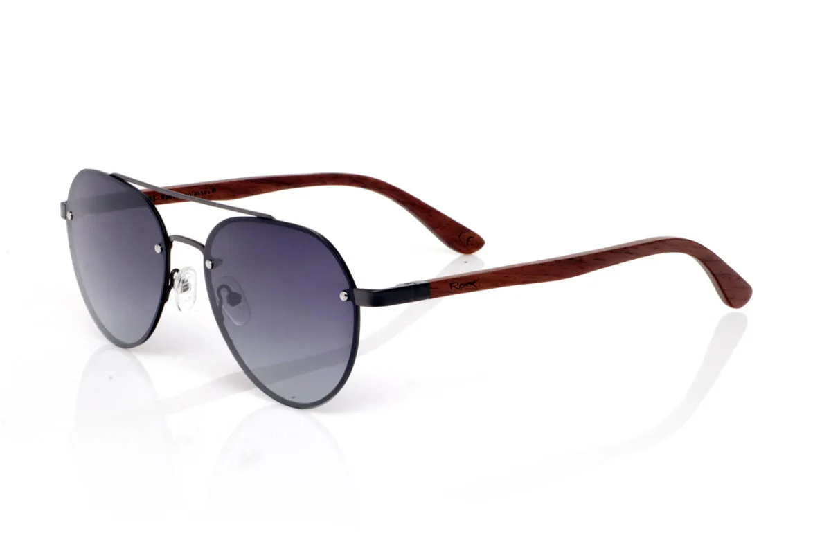 Gafas de Madera Natural de Walnut MISURI ST. Las gafas de madera MISURI ST apuestan por un diseño de inspiración aviador con líneas limpias y estructura metálica fina en tono oscuro, que aporta un aire atemporal y fácil de llevar. Su forma equilibrada estiliza sin exagerar, encajando de forma natural en el día a día.

Las varillas de madera de nogal aportan calidez y contraste, con veta visible y un tacto natural que refuerza la esencia del material. La combinación de metal y madera crea un conjunto ligero, cómodo y con carácter sutil. De esas gafas que acompañan sin imponerse.

Protección completa frente a los rayos UV.

Medidas: 144x51
Calibre: 54 Venta al Por Mayor y Detalle | Root Sunglasses® 